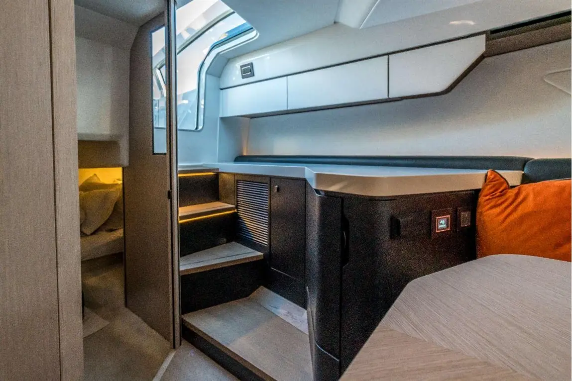 Modern boat interior featuring steps, a small kitchen area, and an inviting dark and light color scheme.